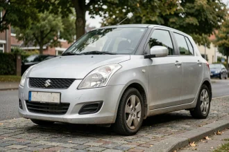 Suzuki Swift 1.3 DDiS diesel garée dans une rue résidentielle, vue 3/4 avant illustrant la fiabilité au quotidien